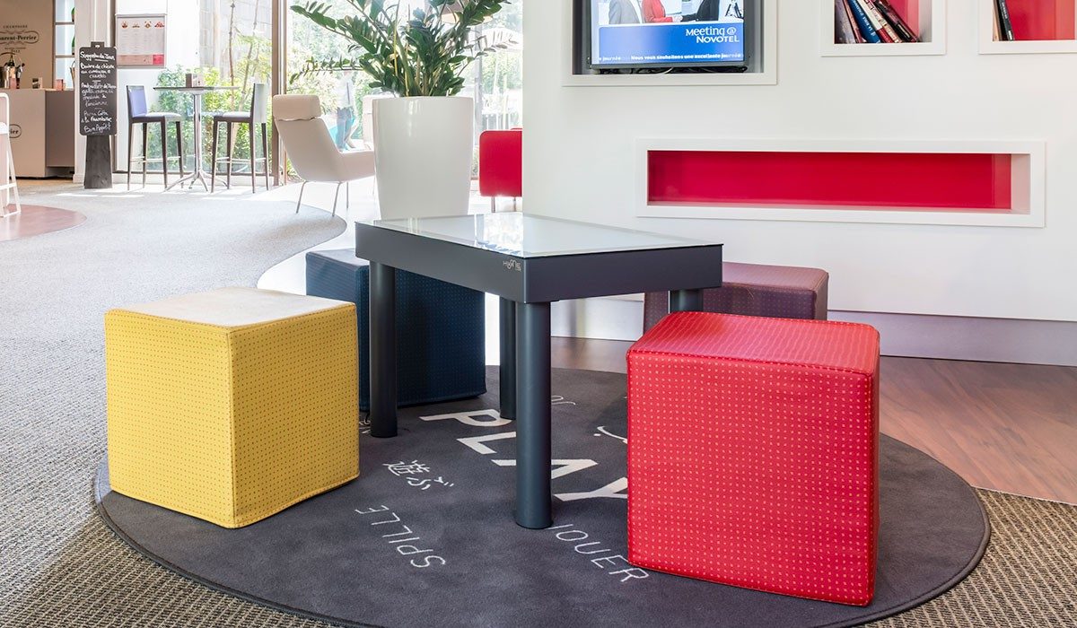Interactive table with colorful stools in a hotel lounge