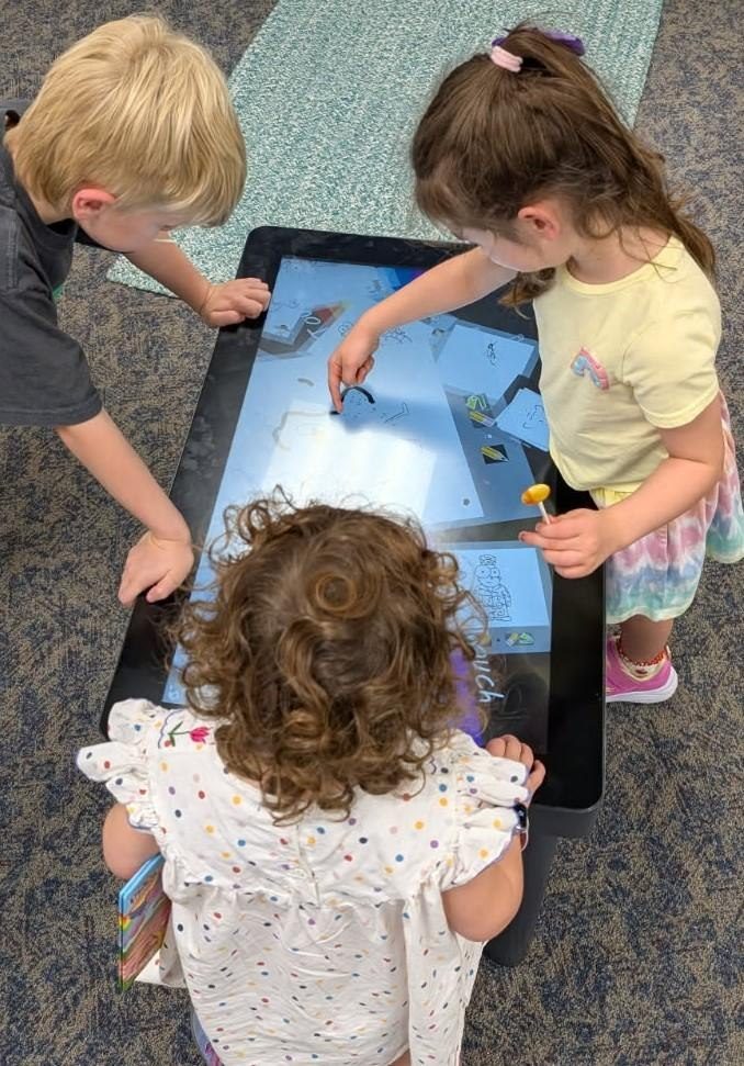 Children gathered around a table running Paint’Touch