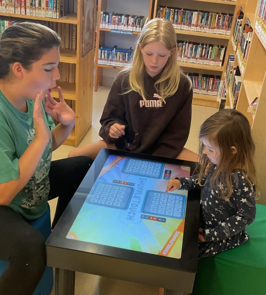 Children playing Shuffle’Touch at a library touch table